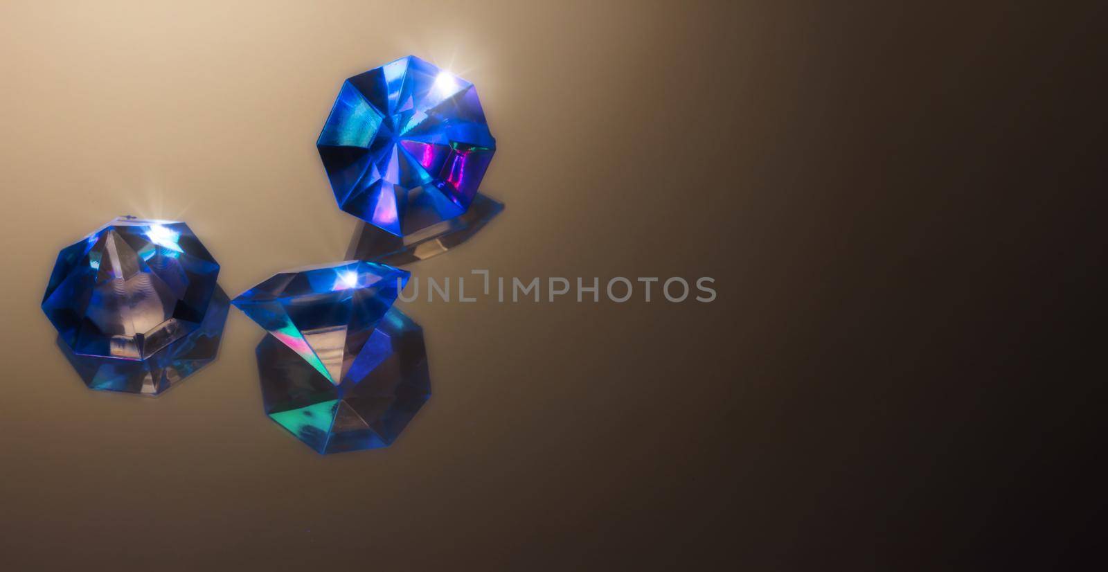 Blue gemstones on a dark background reflecting light