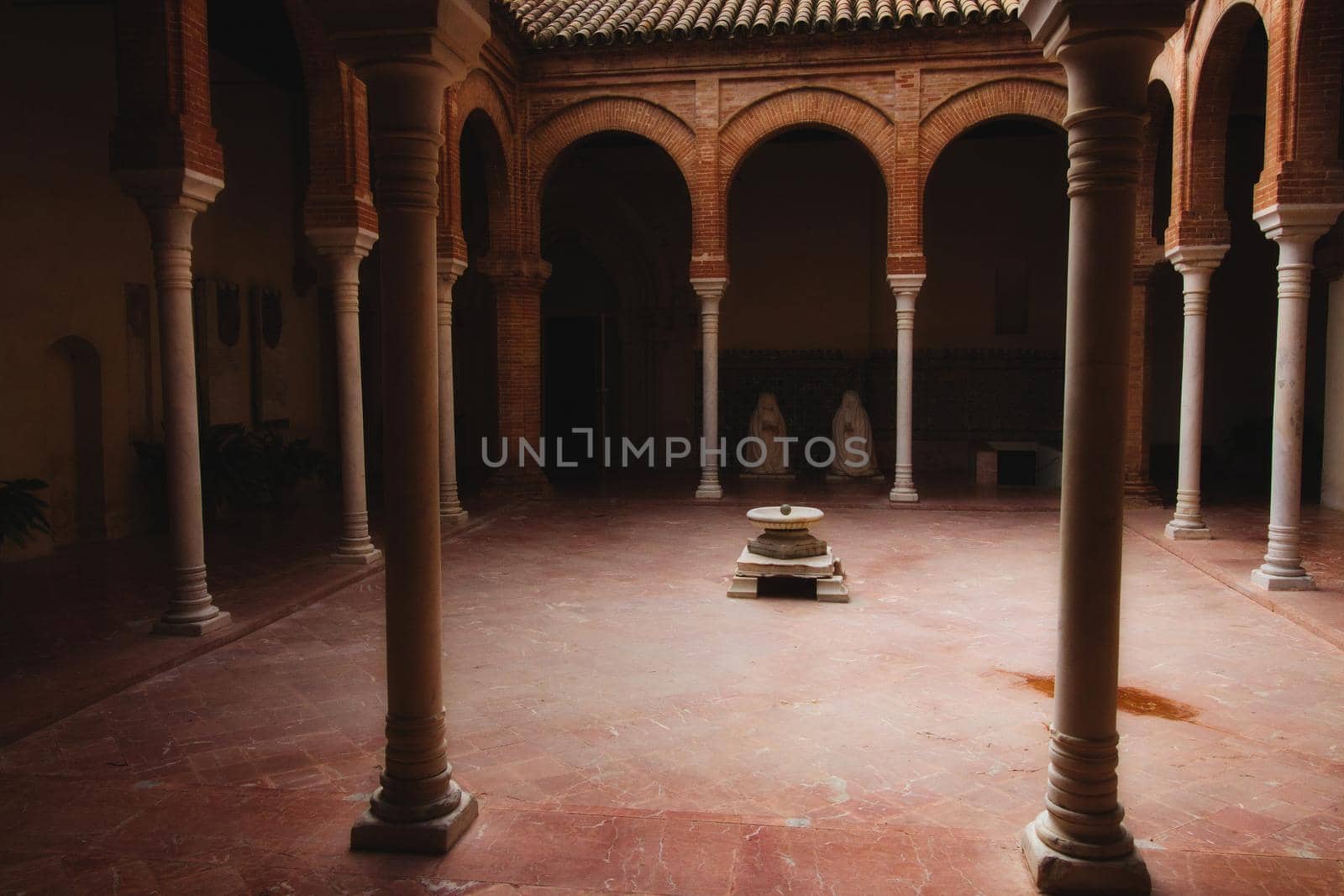 A traditional interior patio with old-fashioned columns and arches by tennesseewitney