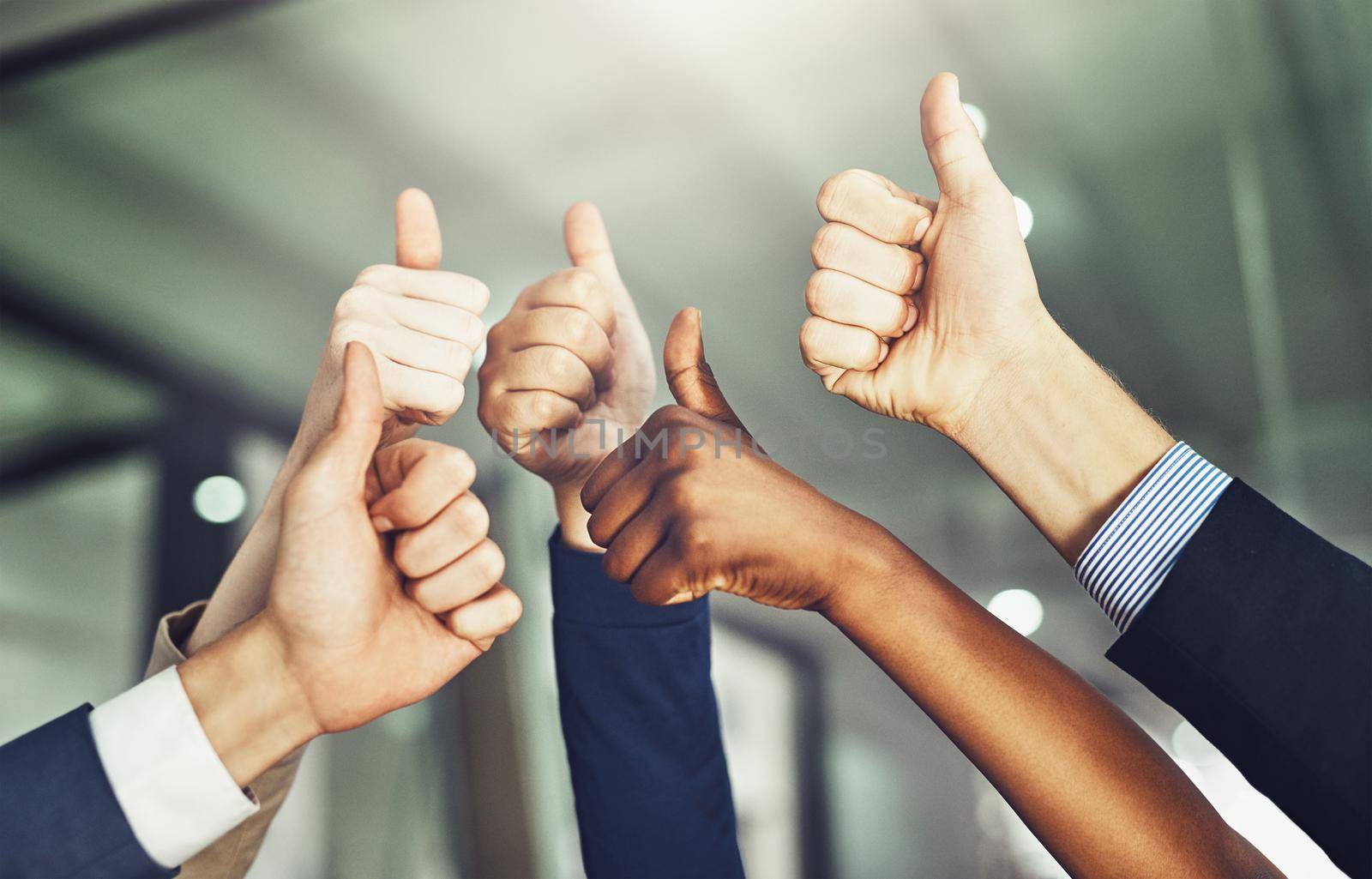 Success should be shared. Cropped shot of a group of businesspeople showing a thumbs up gesture. by YuriArcurs