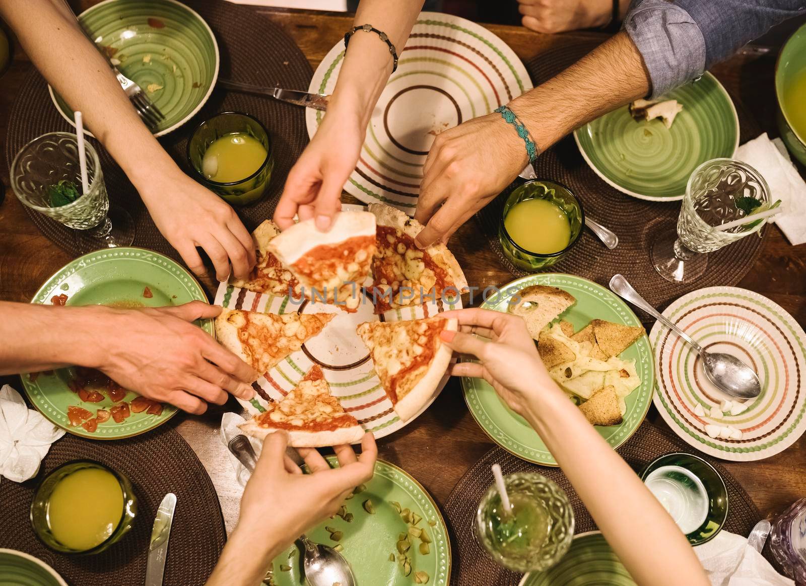 Friends sharing pizza at home.