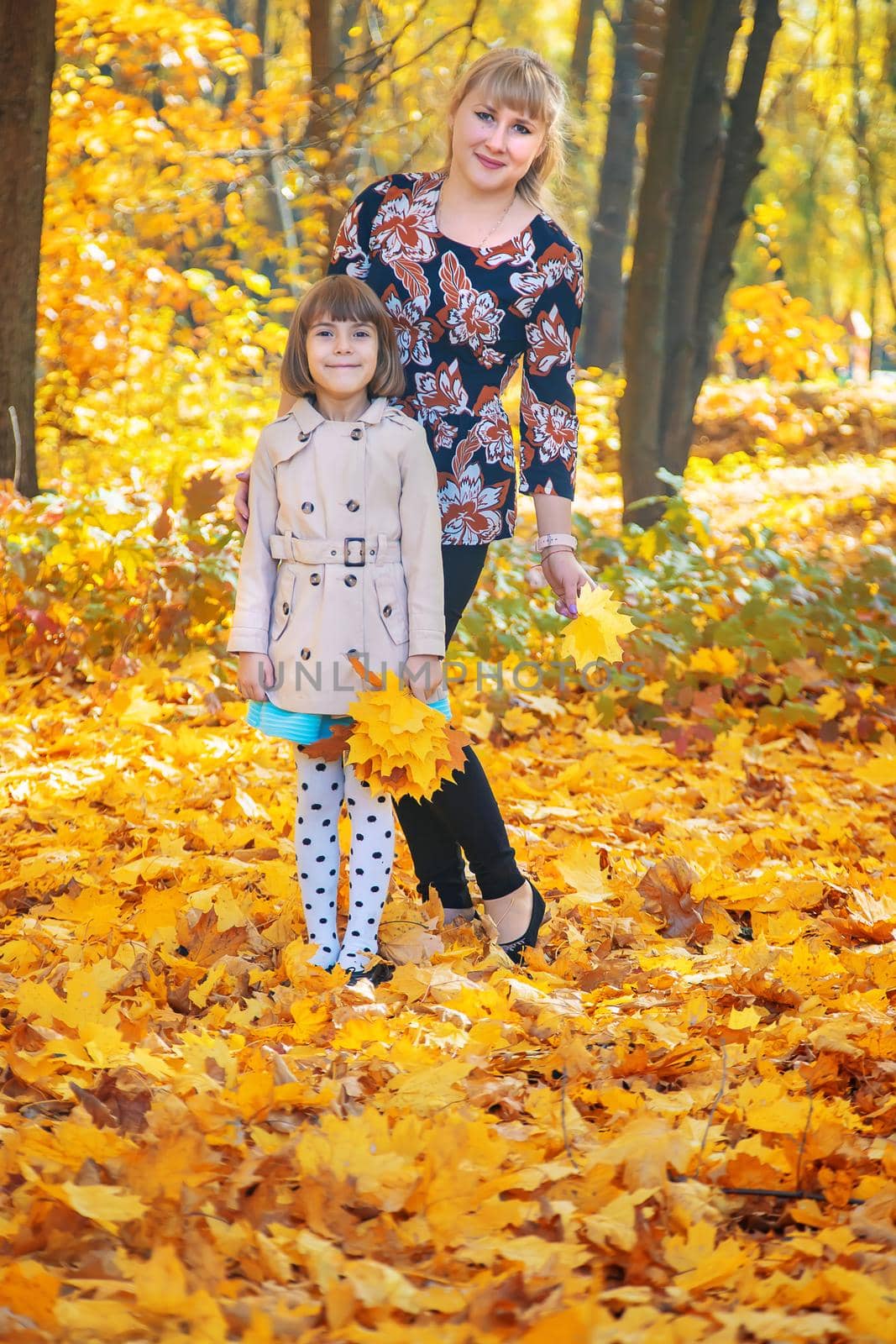 Daughter with mom in the autumn park. Selective focus.