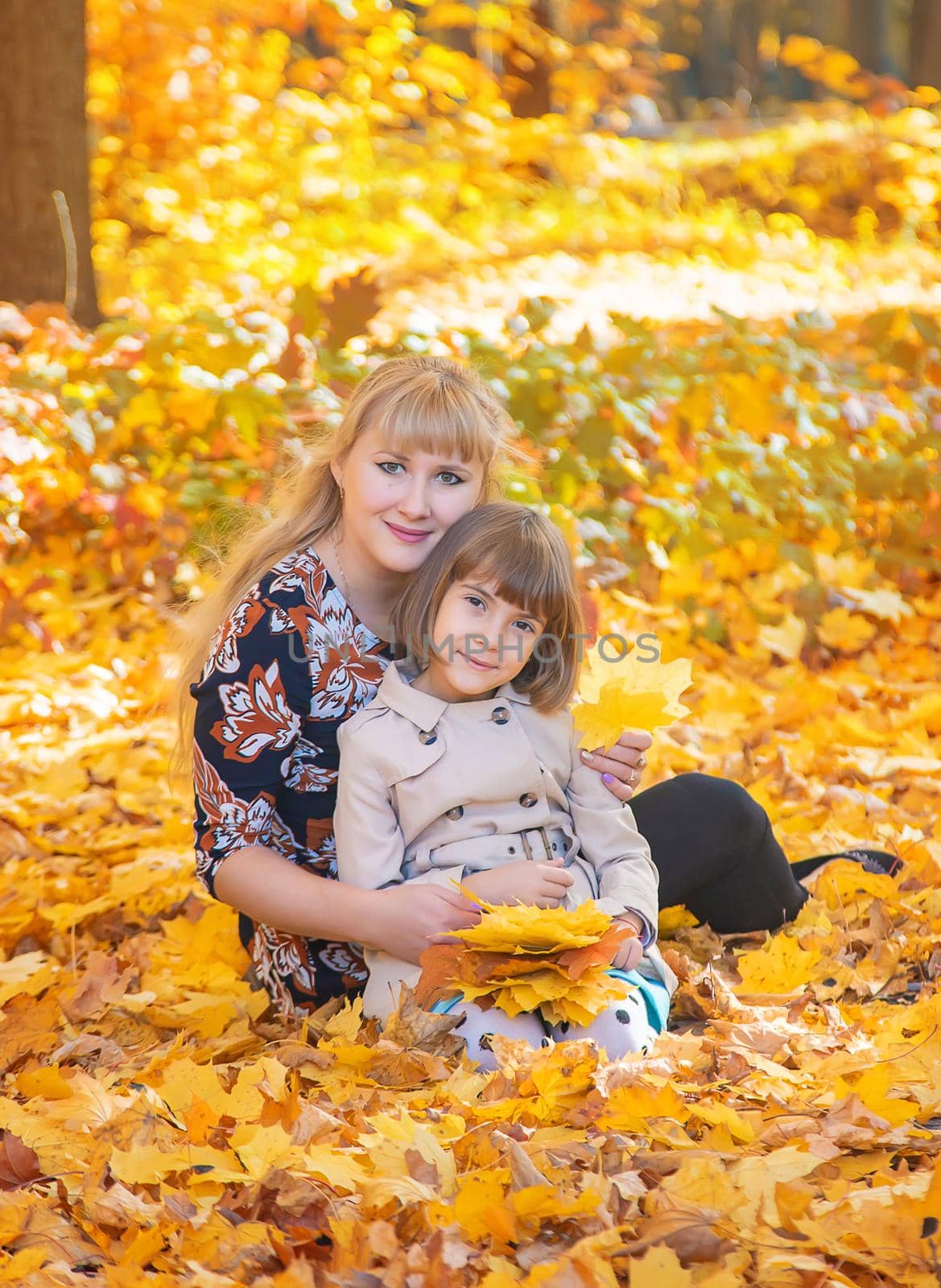 Daughter with mom in the autumn park. Selective focus.