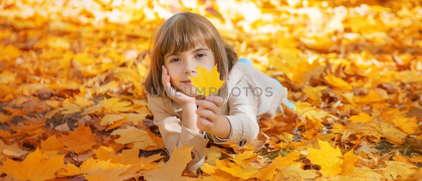 Children in the park with autumn leaves. Selective focus. by yanadjana