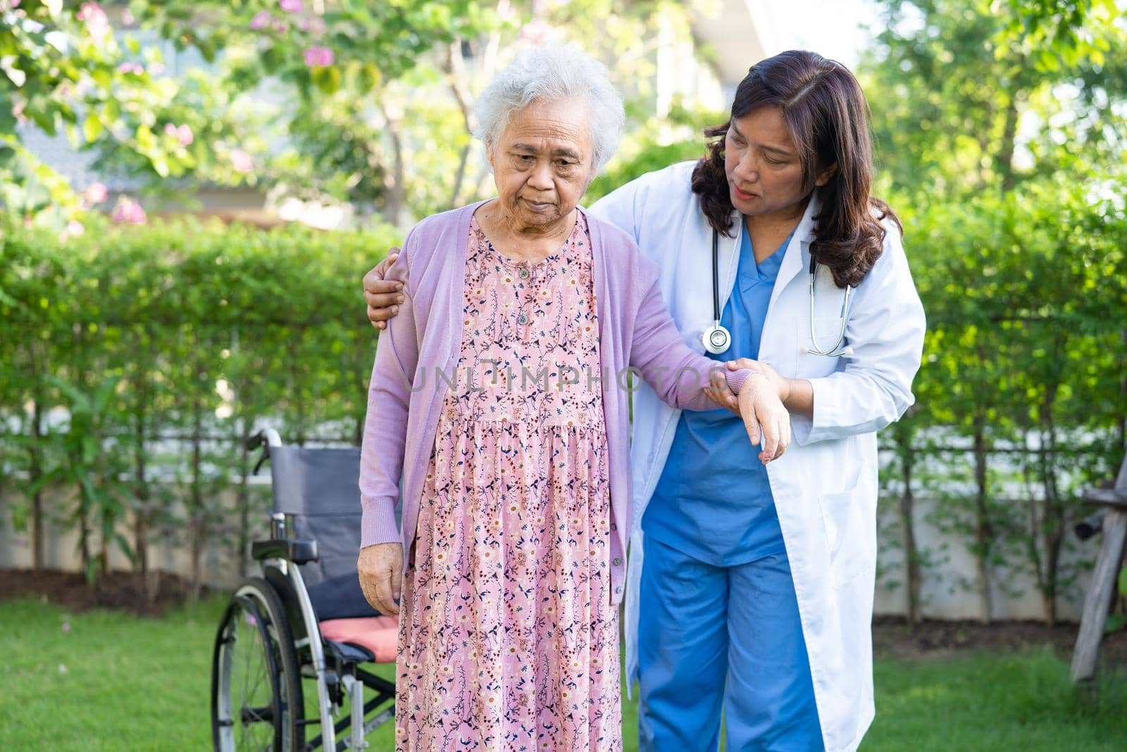 Doctor help and care Asian senior or elderly old lady woman patient sitting on wheelchair at nursing hospital ward, healthy strong medical concept by pamai