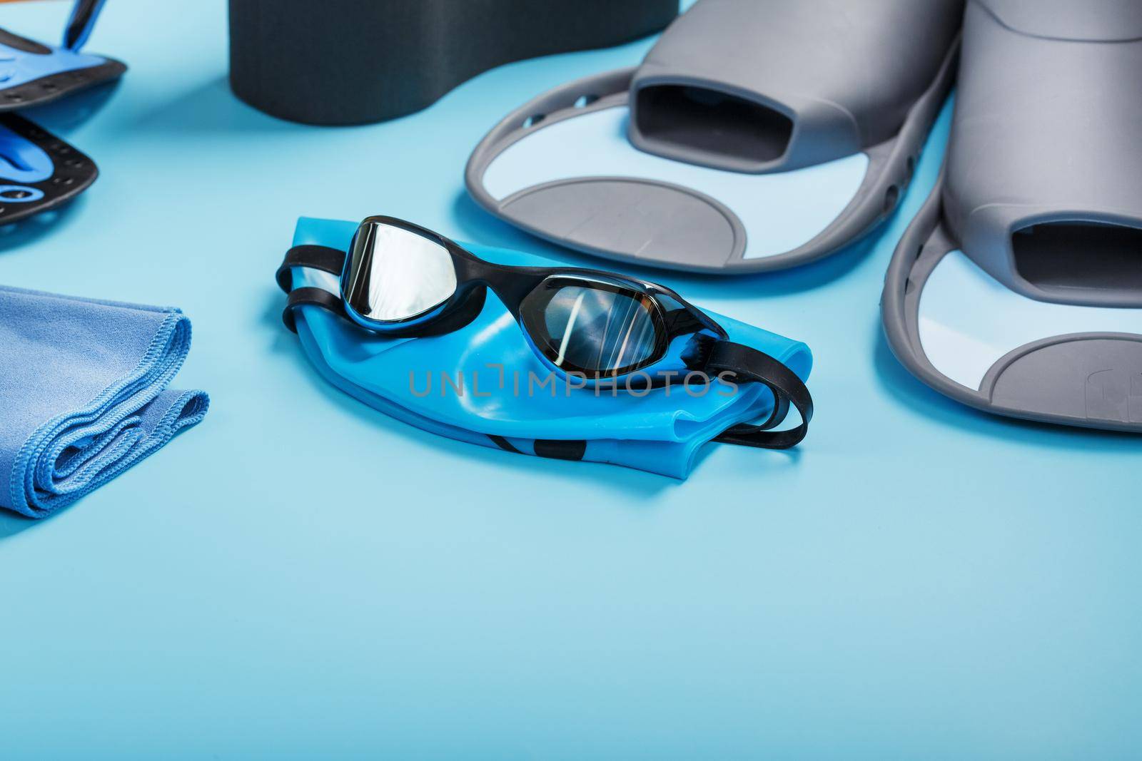 Sports equipment for swimming in the pool and open water on a blue background, close-up