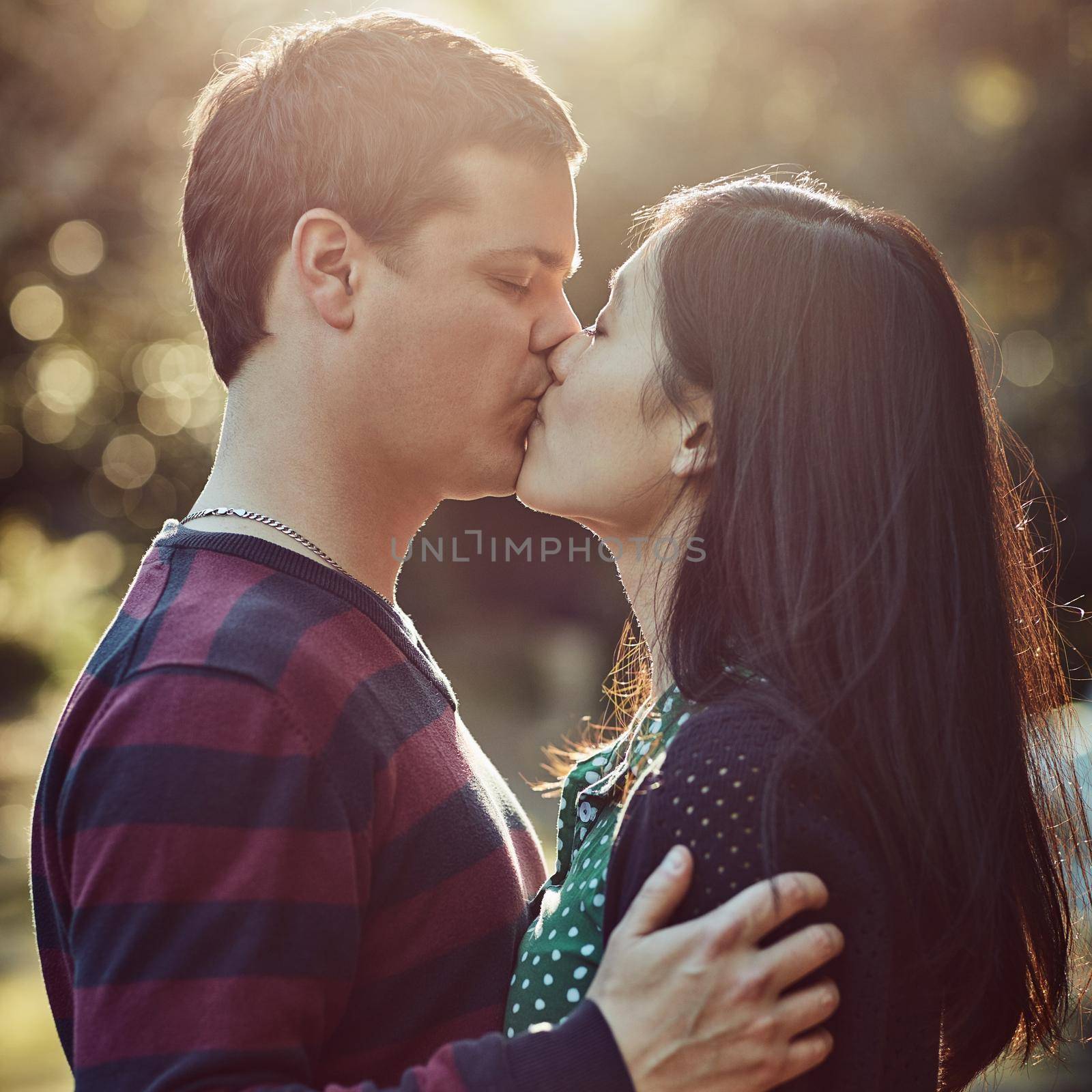 Shot of an affectionate young couple kissing outdoors.