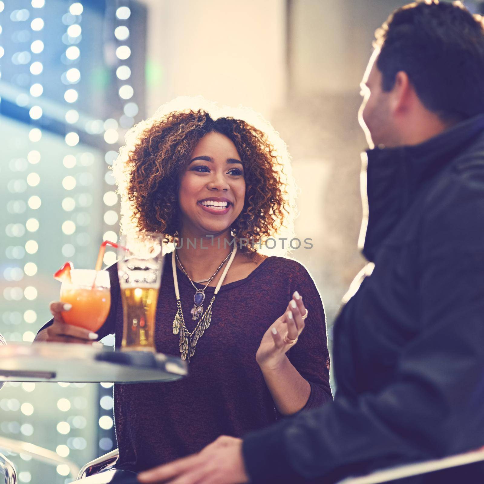 Drinks are on you, right. Shot of two friends relaxing with cocktails in a nightclub. by YuriArcurs