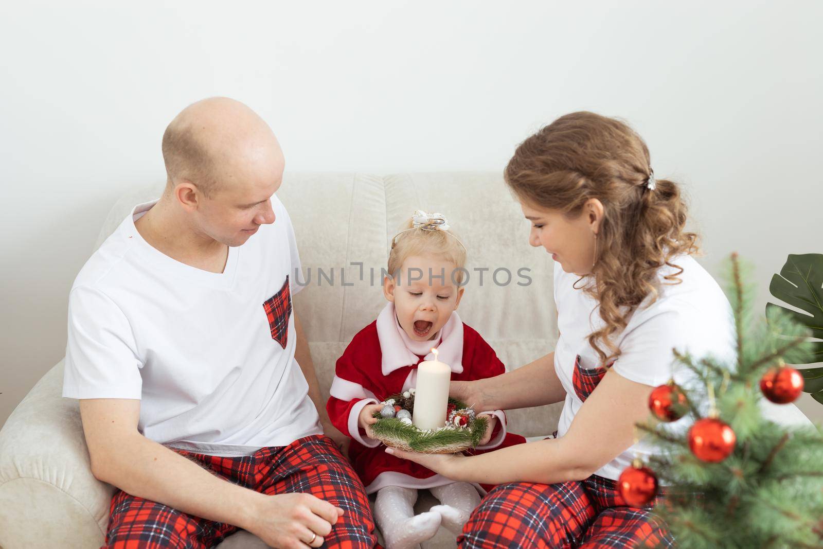 Baby child with hearing aid and cochlear implant having fun with parents in christmas room. Deaf , diversity and health concept by Satura86