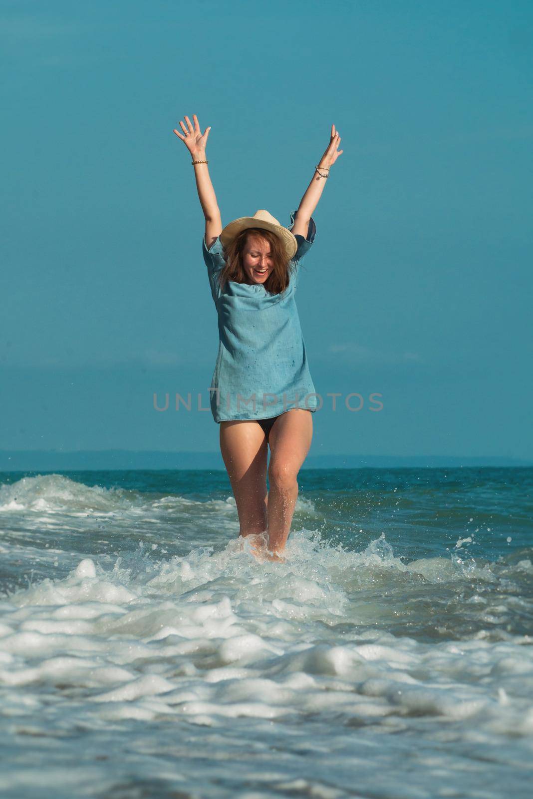 a beautiful girl in summer on the seashore happily having fun on the water with emotions by Rotozey