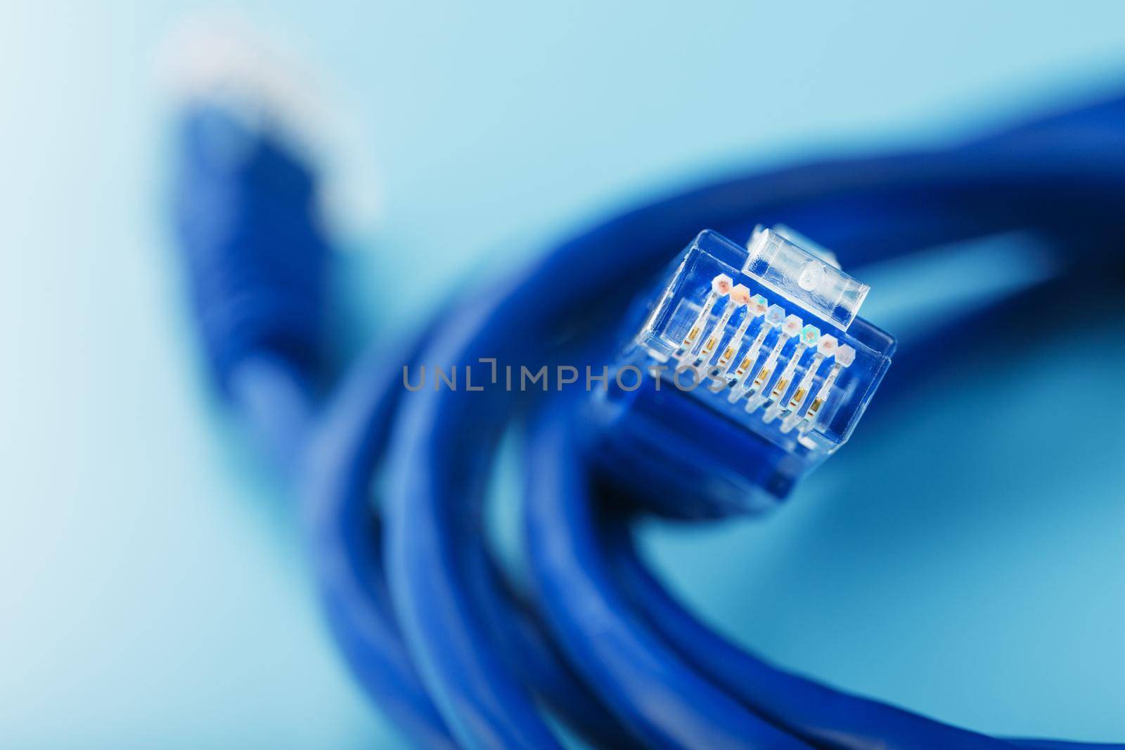 A coil of an Internet network cable for data transmission on a blue background by AlexGrec