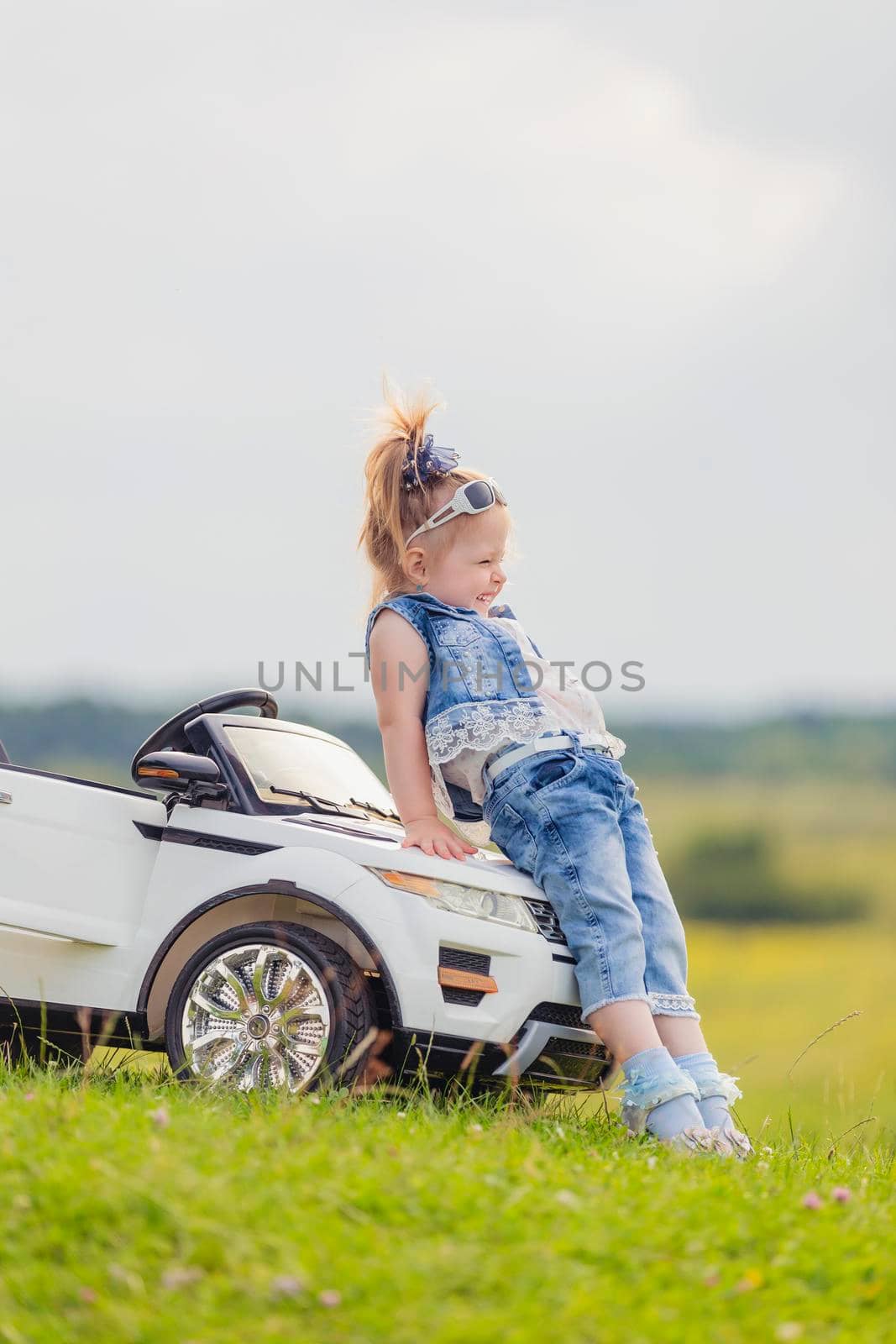 little girl standing near her baby car