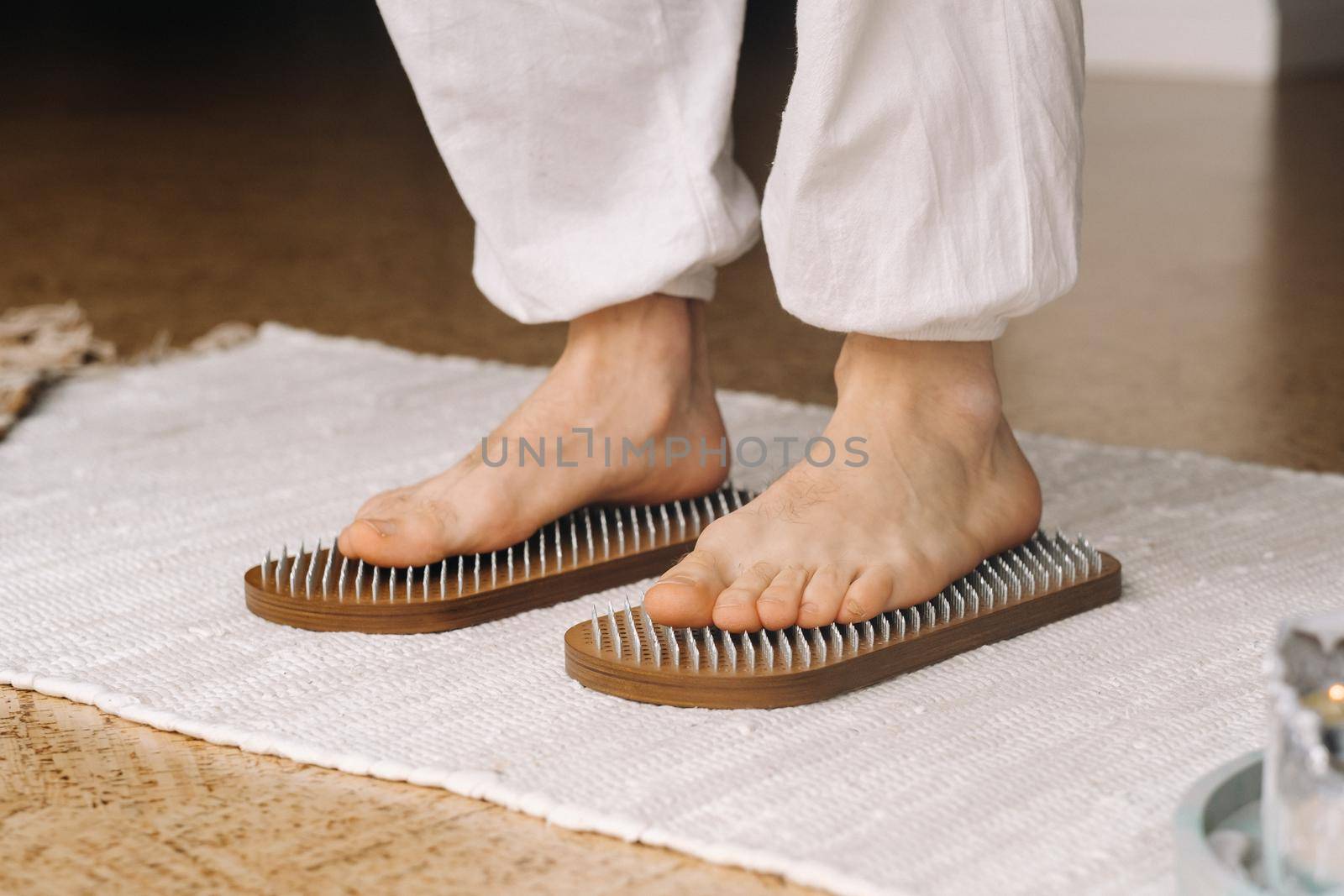 The man's feet are next to boards with nails. Yoga classes.