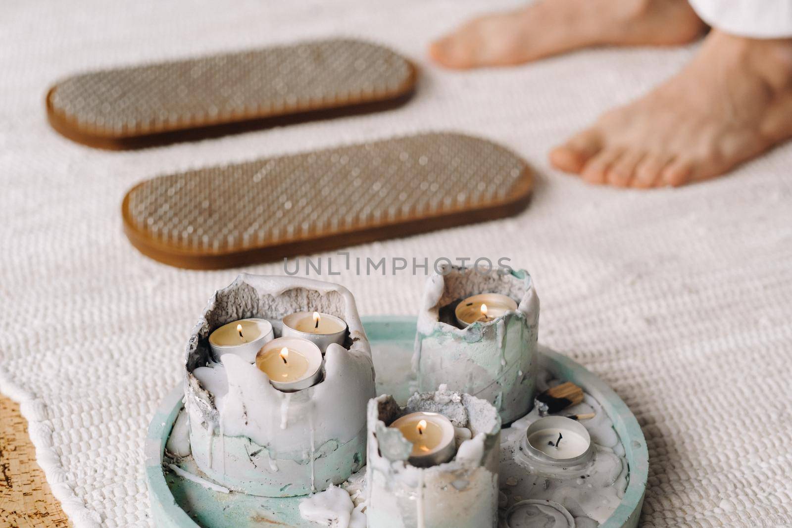 The man's feet are next to boards with nails. Yoga classes.