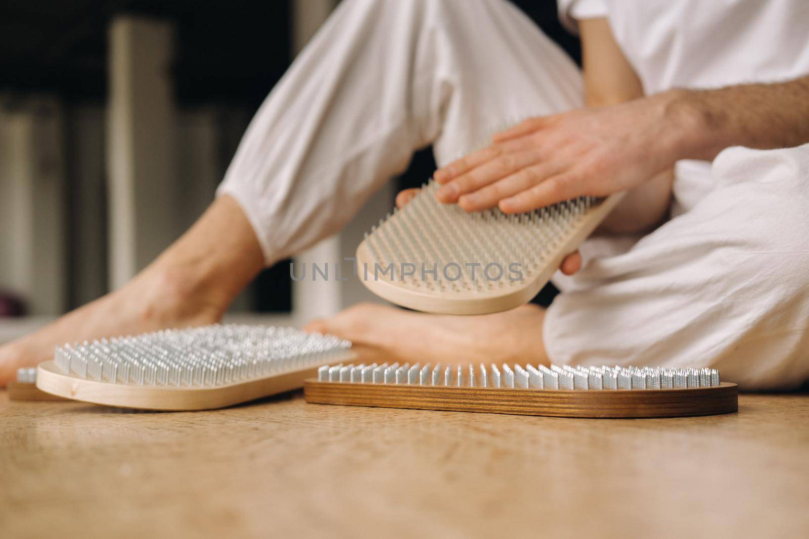 A man holds in his hands boards with nails for yoga classes.