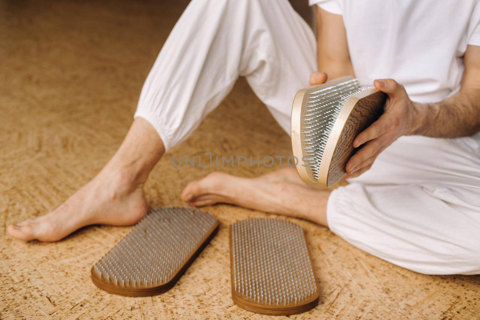 A man holds in his hands boards with nails for yoga classes.