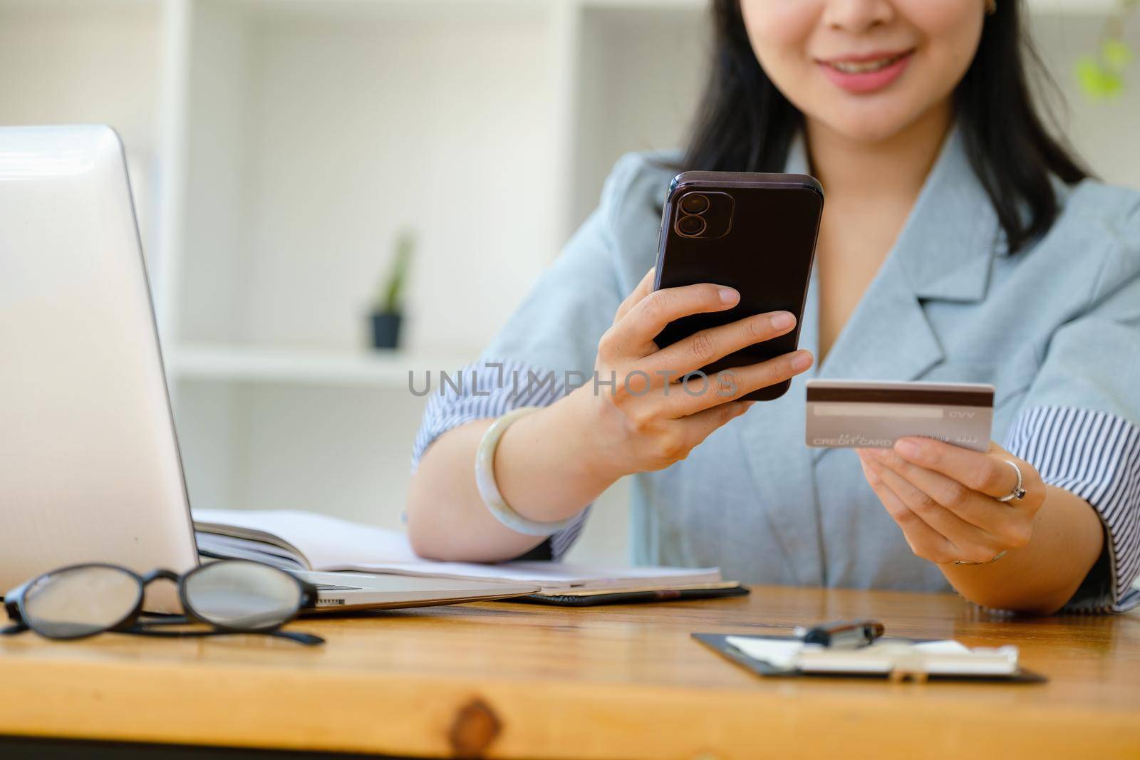 Online Shopping and Internet Payments, Asian women are using their smartphone mobile and credit cards to shop online or conduct errands in the digital world.