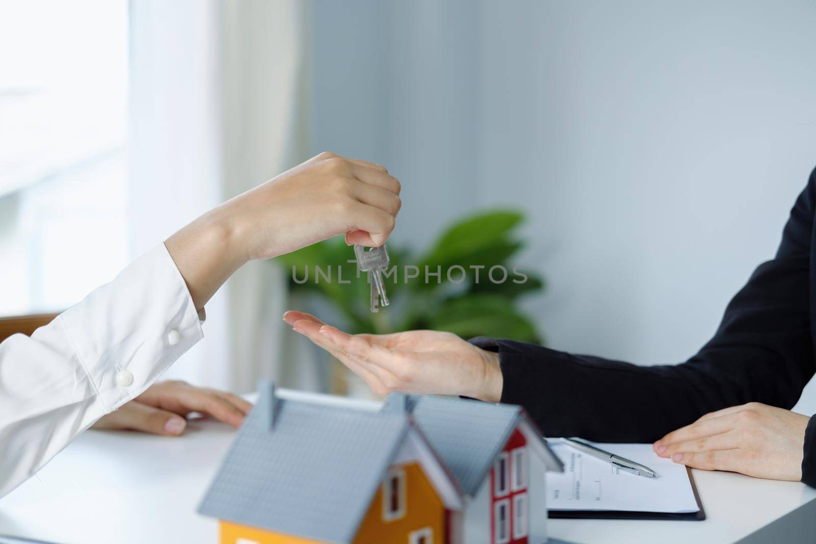 Guarantee, mortgage, agreement, contract, sign, real estate agent delivers the keys to the customer after signing important contract documents by Manastrong