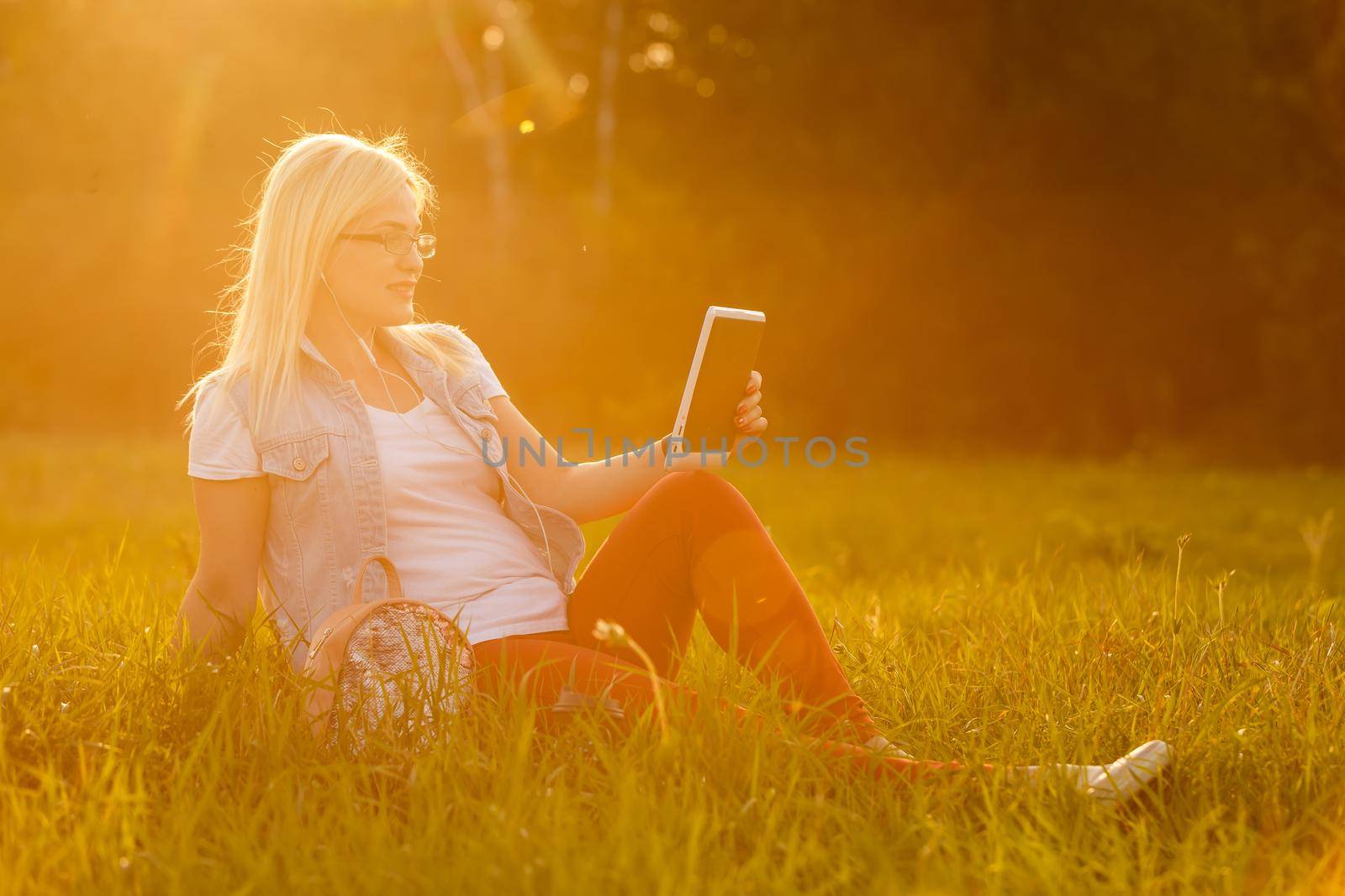 woman with tablet in the park by Andelov13
