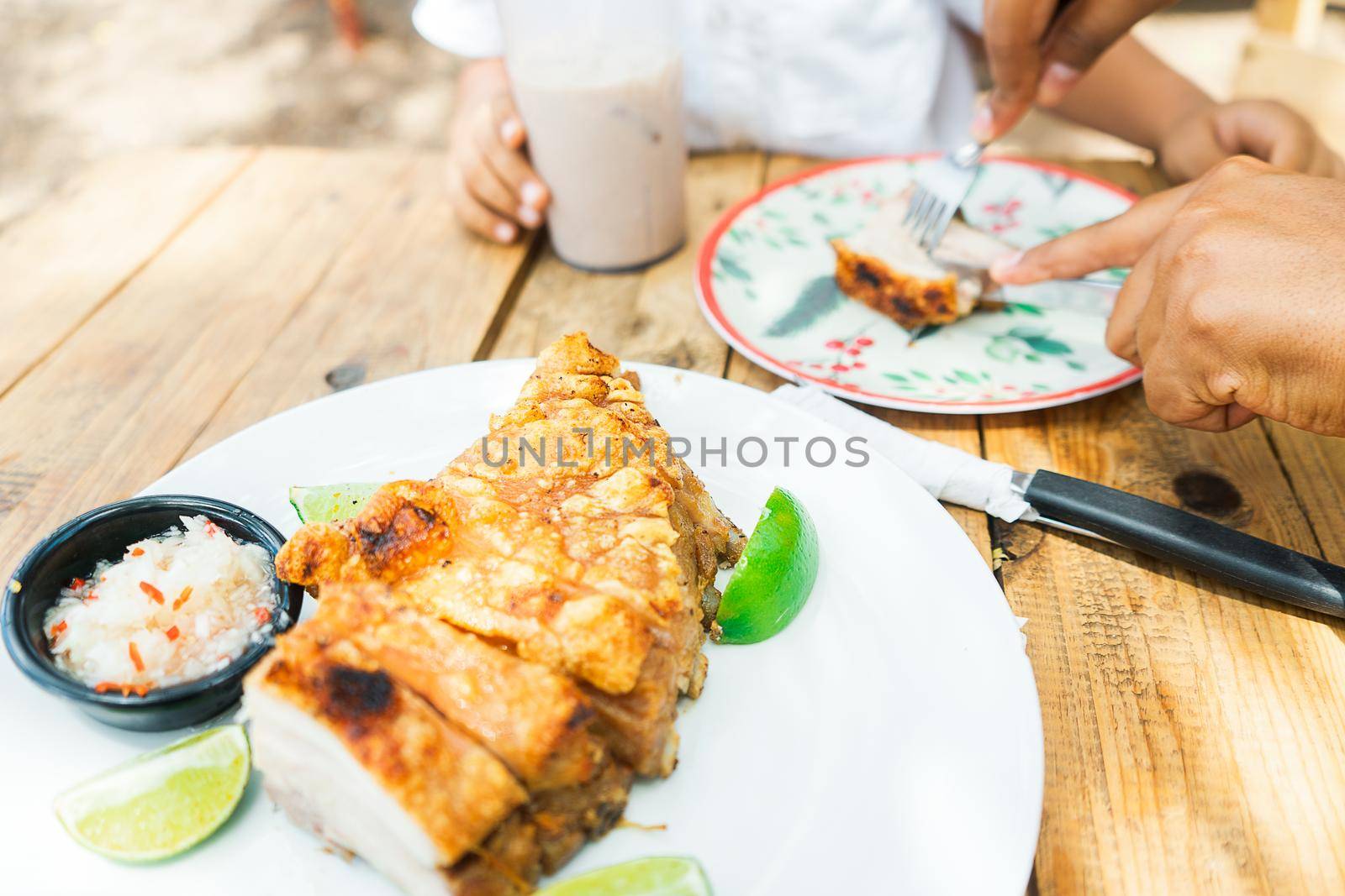 Closeup at the table of a family from Nicaragua eating pork belly