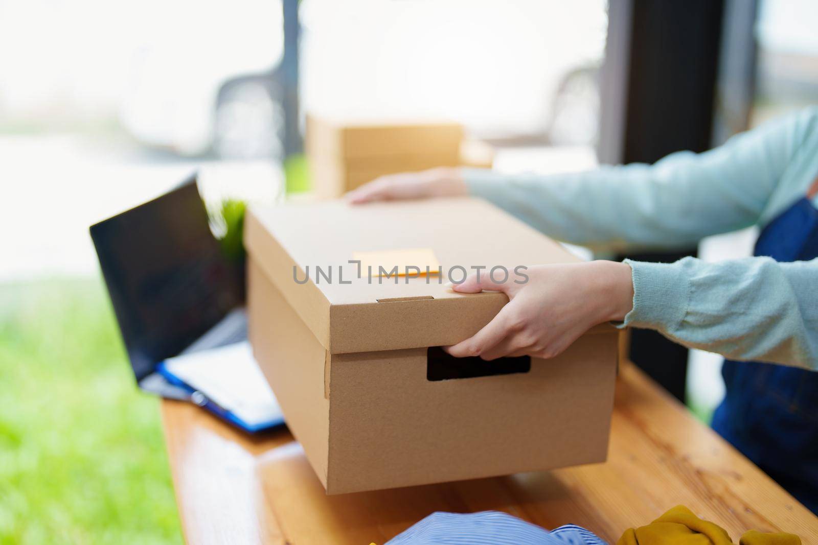 Portrait of a business woman, sme packing products in boxes and showing delivery to customers according to their orders by Manastrong