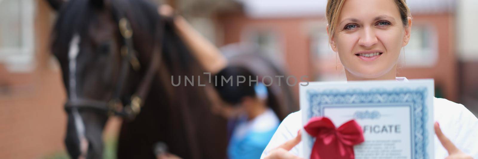 Woman doctor shows horse veterinary certificate, close-up, blurry. Equestrian sports tourism, competitions