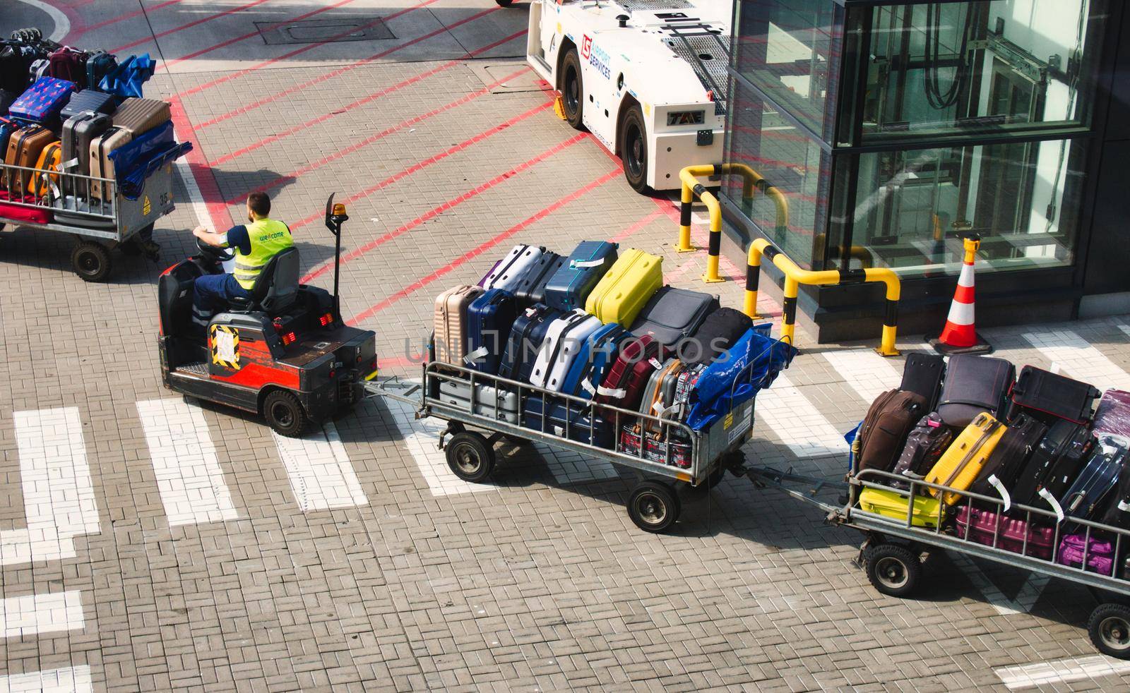 04 August 2019 - London, England: Motorised baggage cart carrying luggage at an airport runway by tennesseewitney