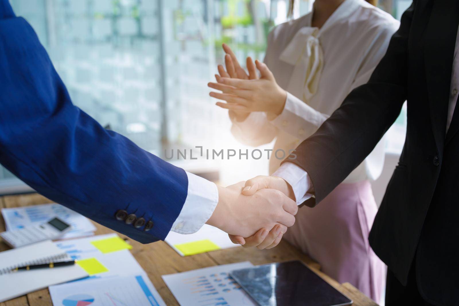 Asian entrepreneurs handshakes to congratulate the agreement between the two companies to enhance investment and financial strength. deal concept by Manastrong