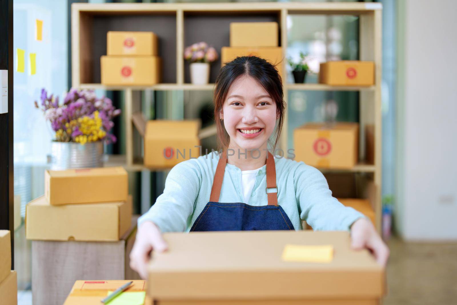 Portrait of a business woman, sme packing products in boxes and showing delivery to customers according to their orders.