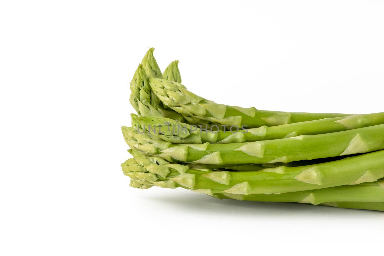 Fresh green asparagus on a white isolated background. Green asparagus isolate with shadow on white background. by SERSOL