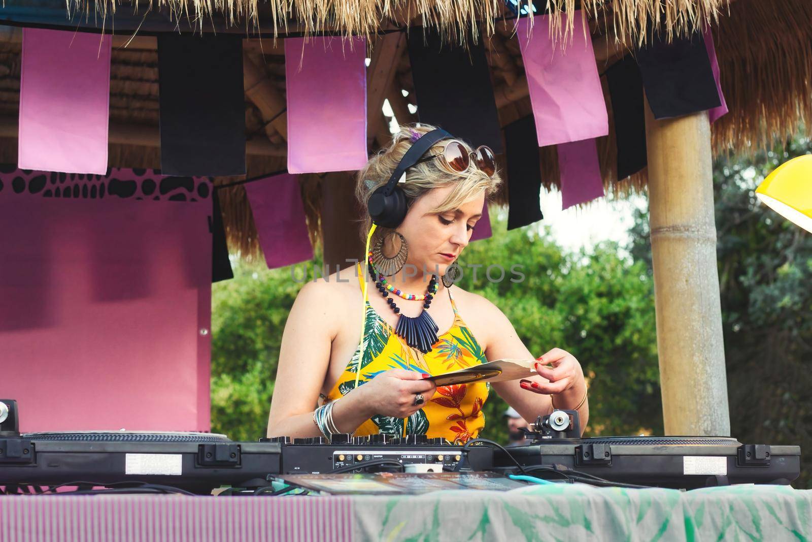 A female DJ using mixing decks with old-fashioned vinyl records outdoors