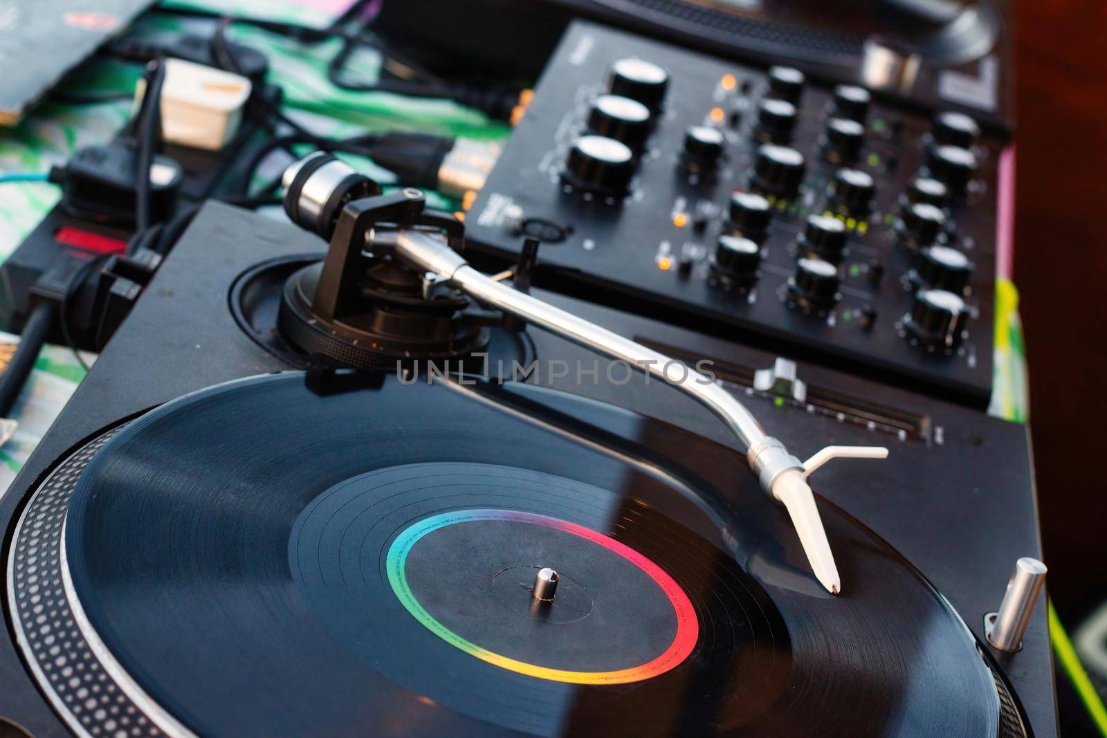 Vinyl record on a deejay's turntable with mixing desk equipment sound system