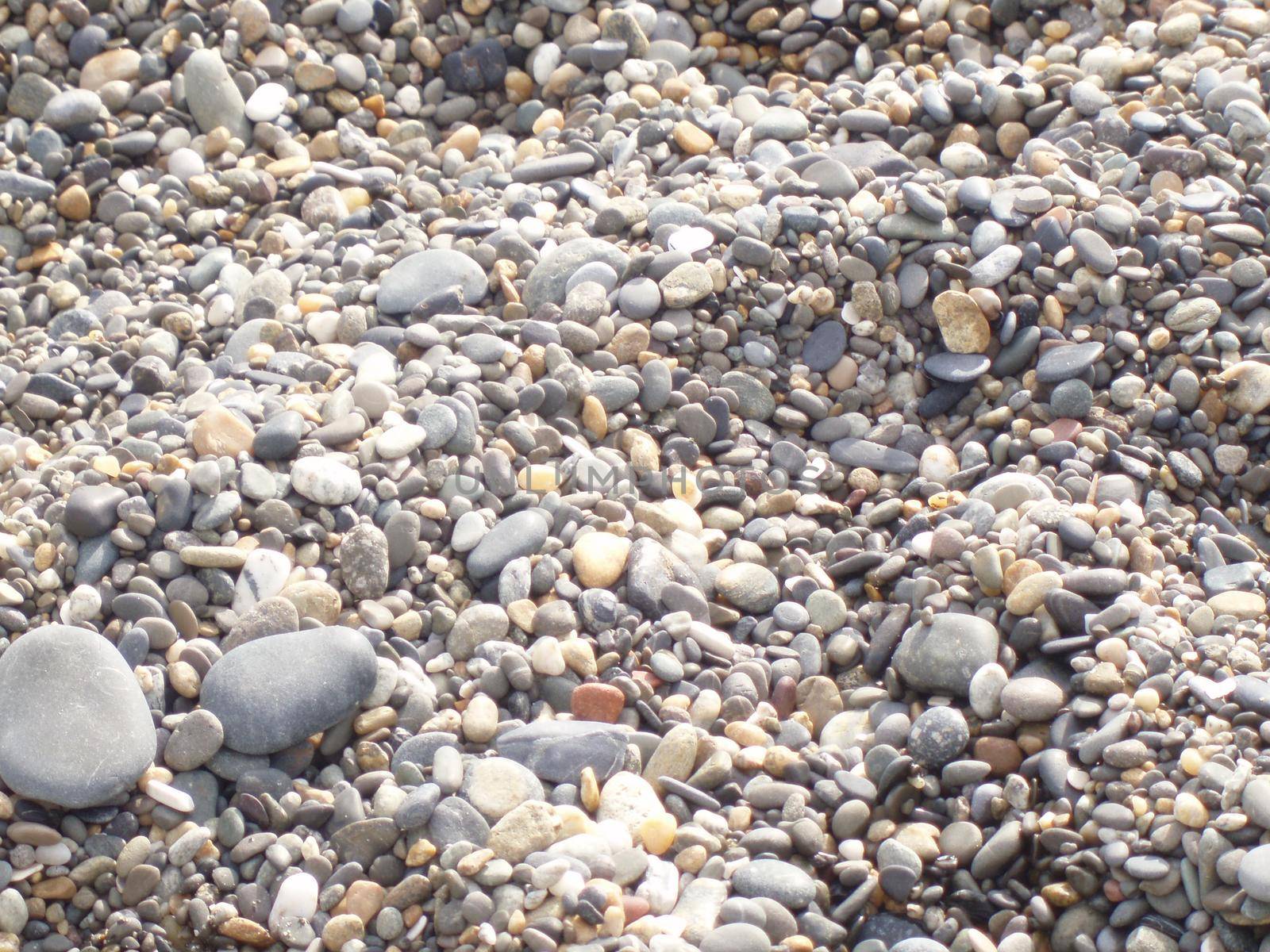 Background stones on the beach. Close up of rounded and polished beach rocks.