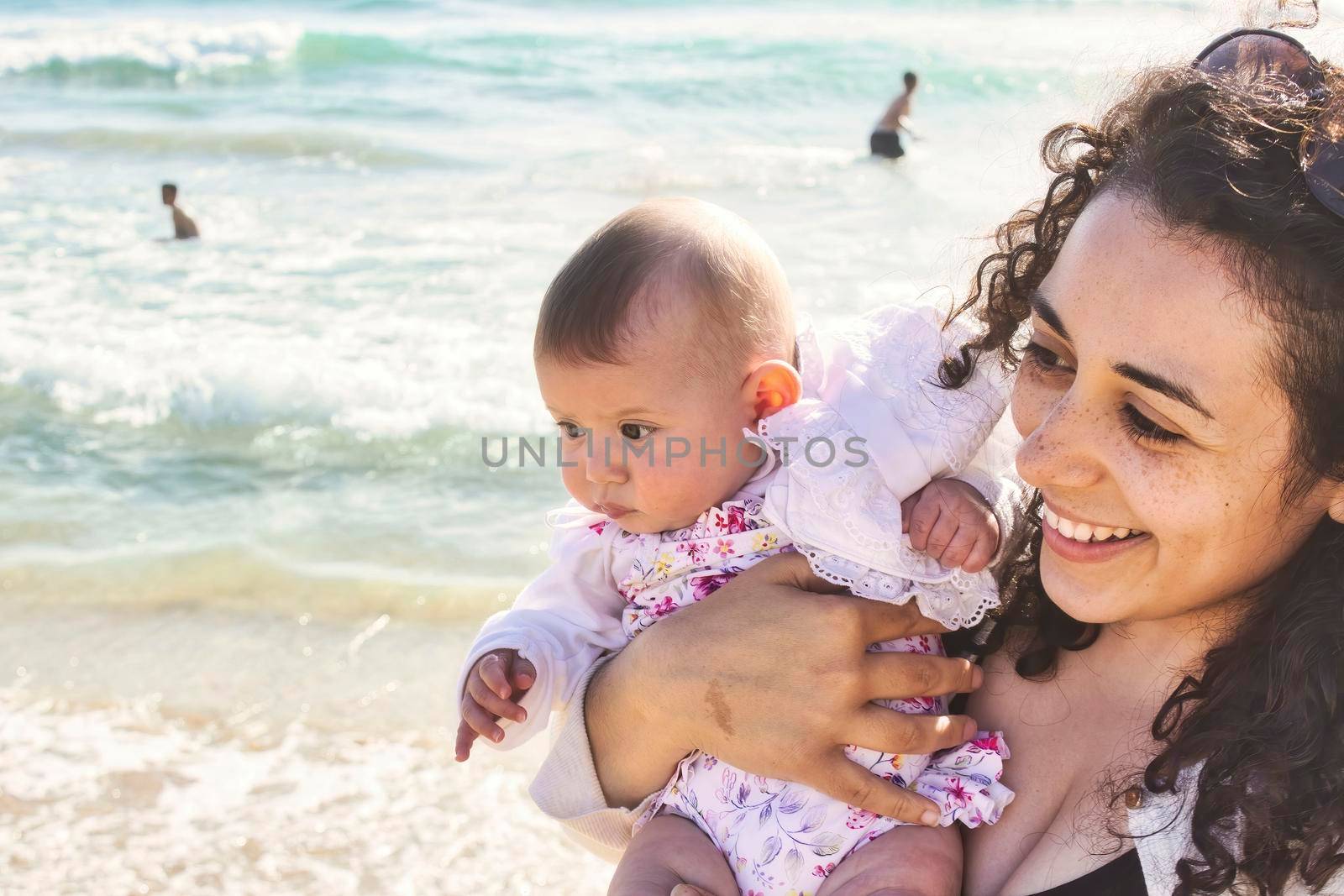 Young mother and daughter baby girl looking happy at the beach by tennesseewitney