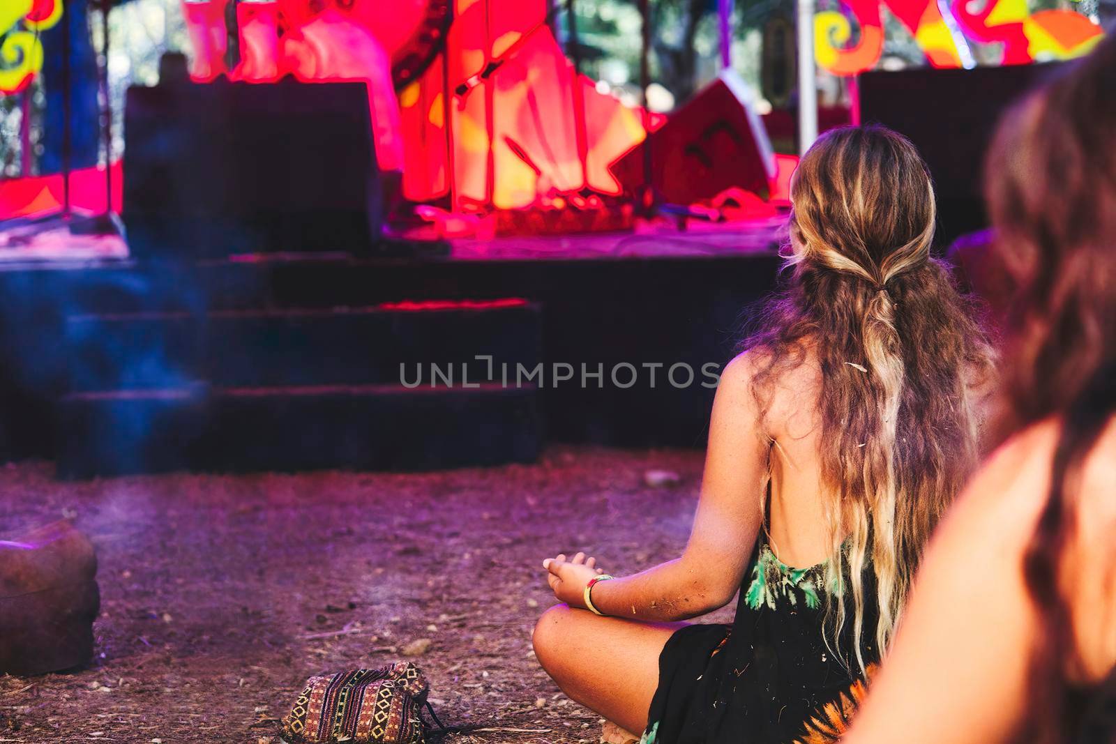 Long haired blonde girl at a new-age festival at an ethnic music concert sitting cross-legged by tennesseewitney