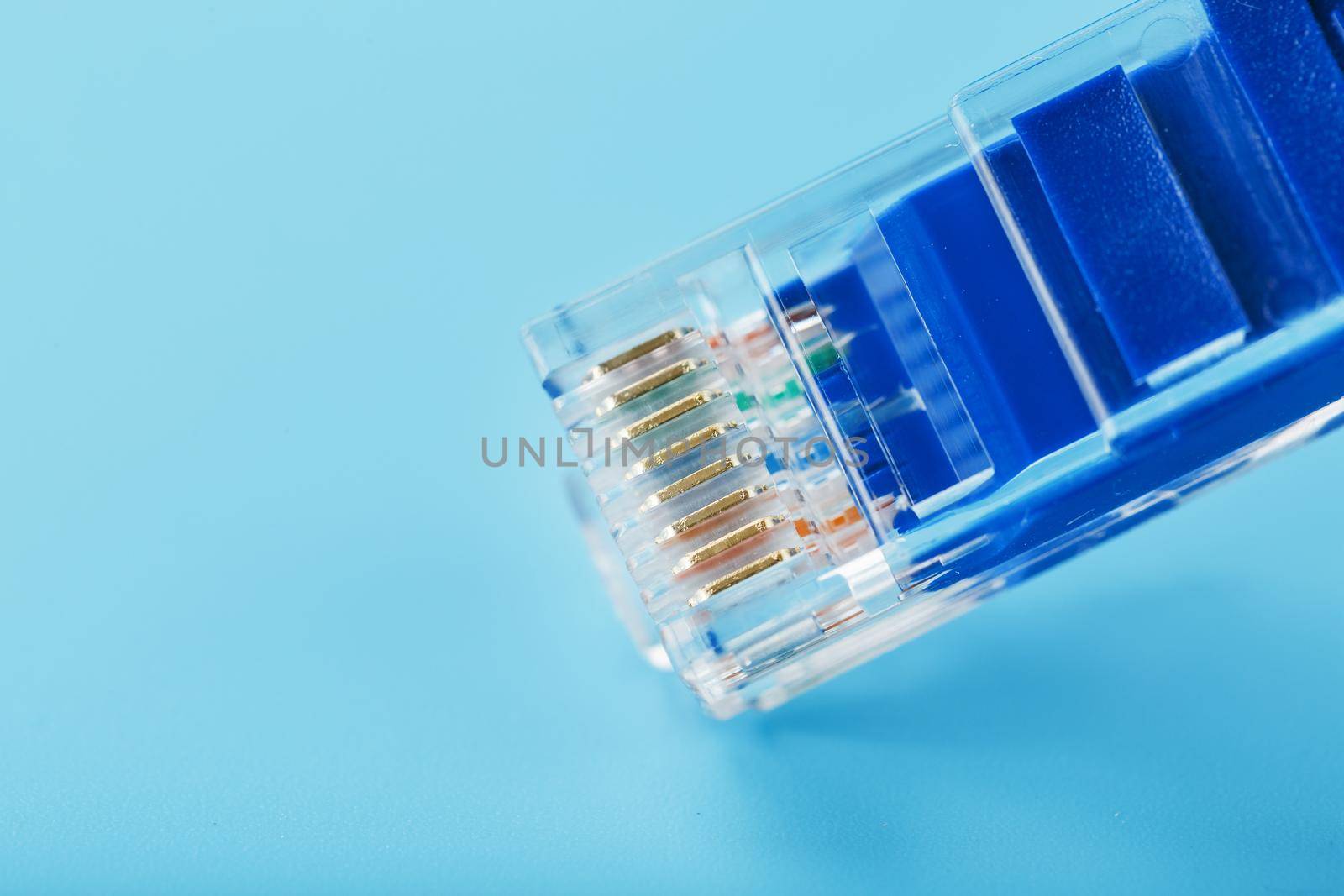 Ethernet Cable connector Patch cord cord close-up on a blue background with free space by AlexGrec