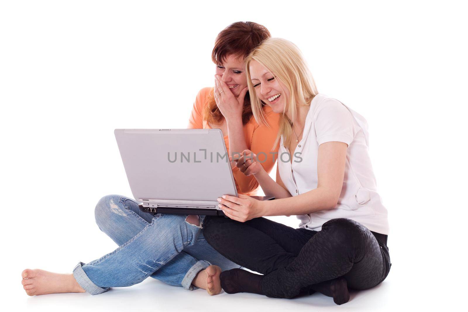 Two young women having a good time on a laptop. Isolated on white.