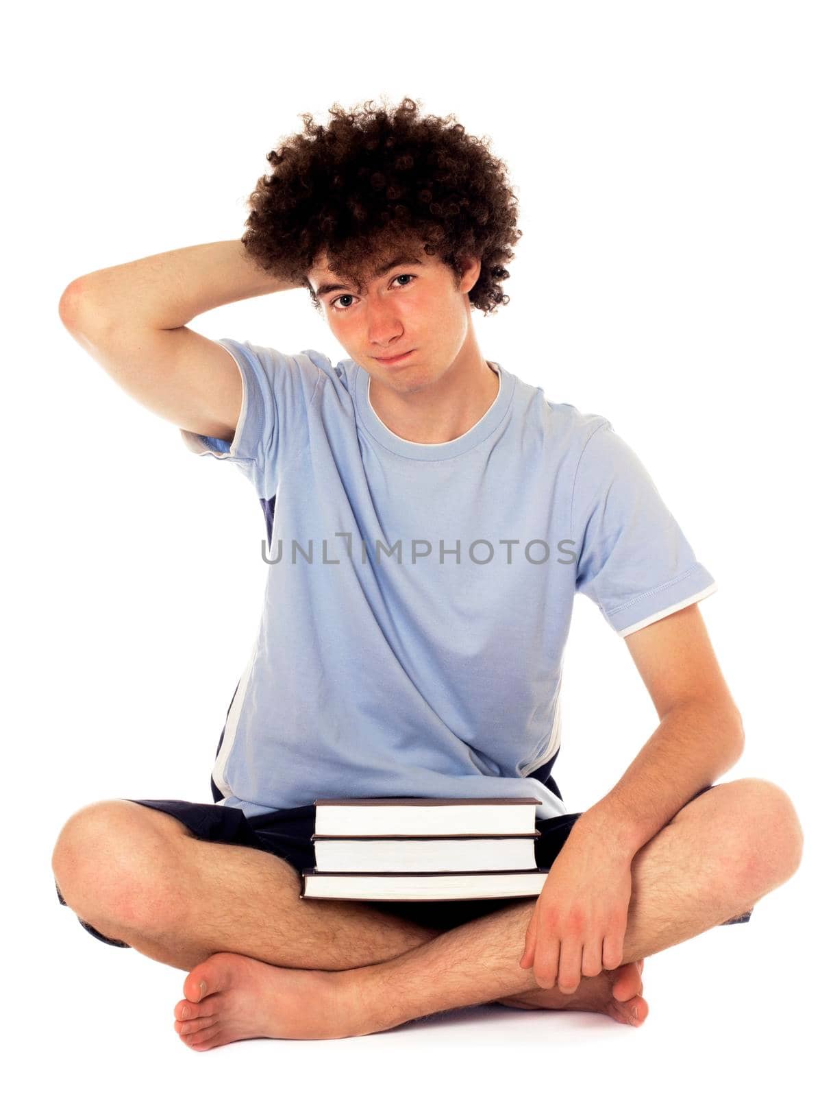 Pensive teenager with books sitting on the floor,looking up and has downcast appearance. Isolated on white.