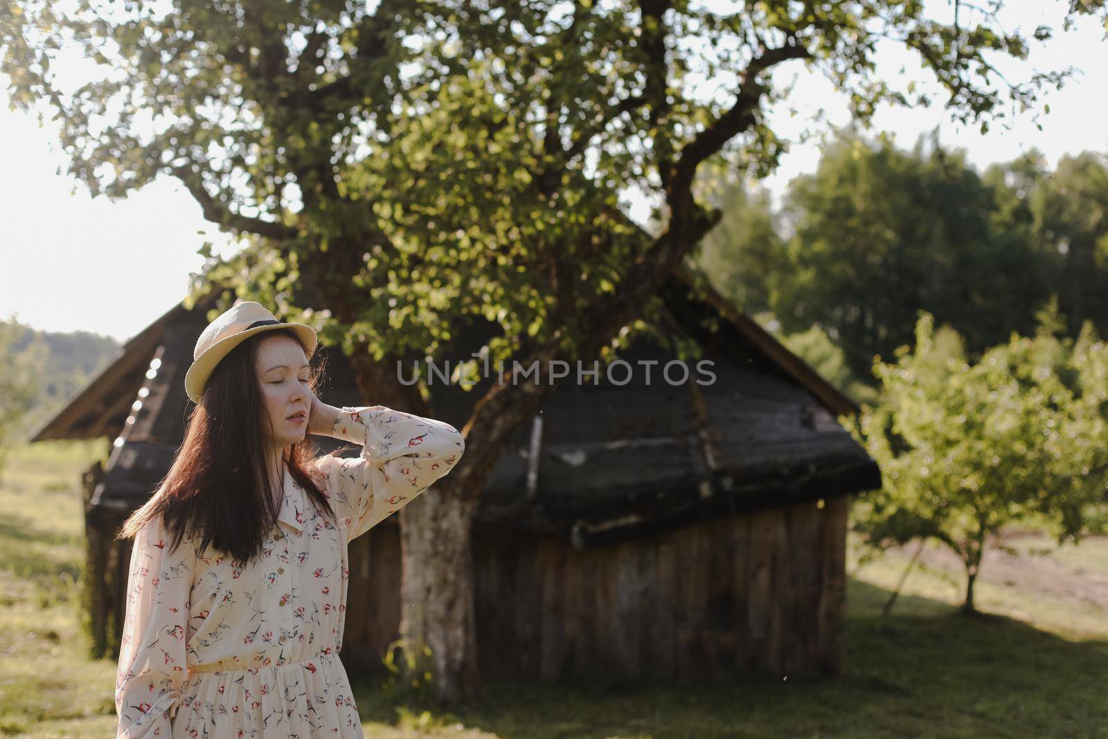 romantic portrait of a young woman in straw hat and beautiful dress in the countryside in summer by paralisart