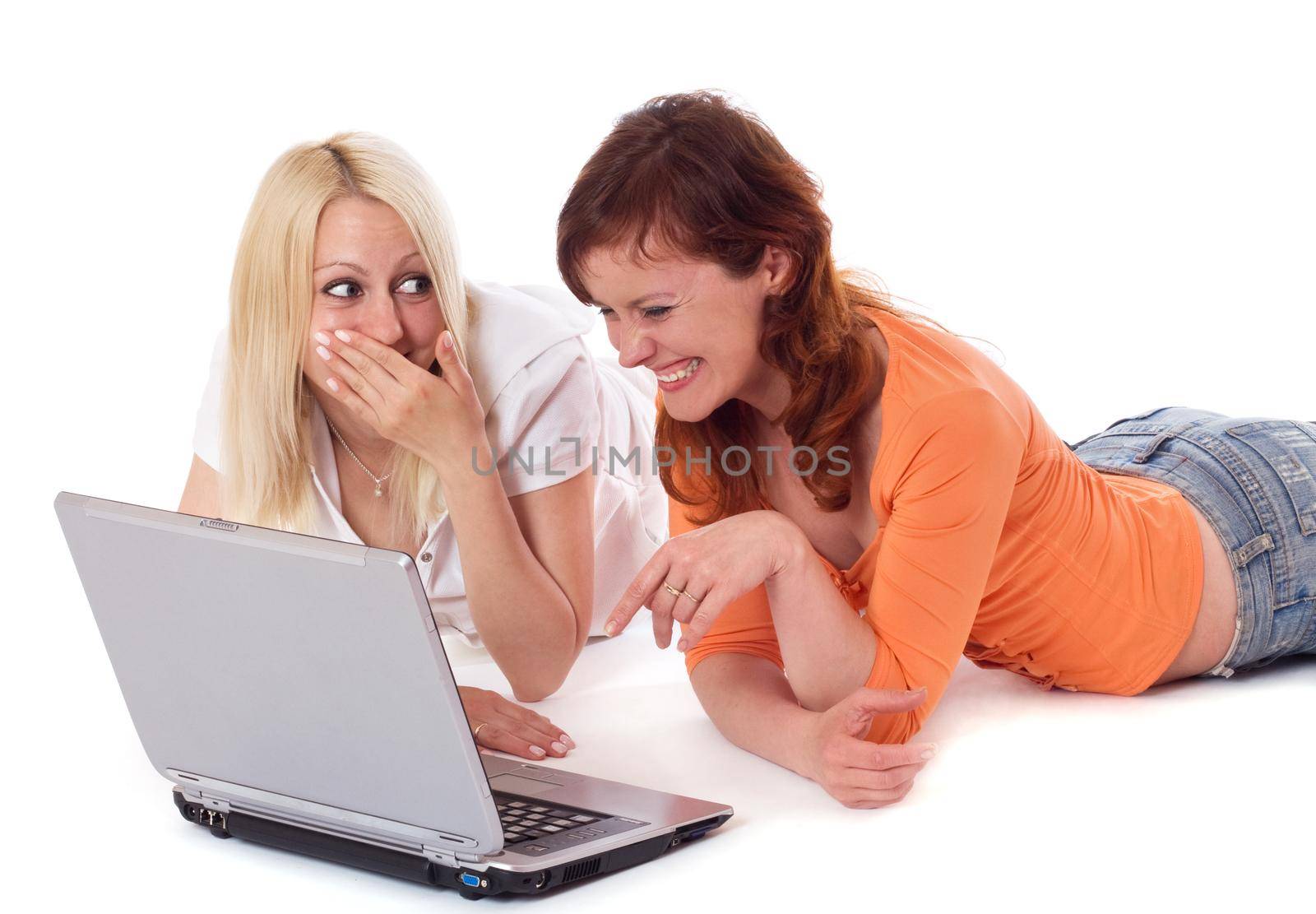 Two young women having a good time on a laptop. Isolated on white.