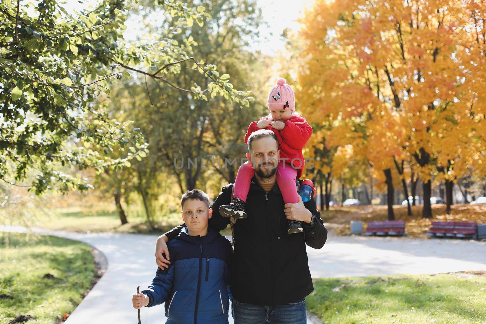 Happy father playing with his children outside in the park.