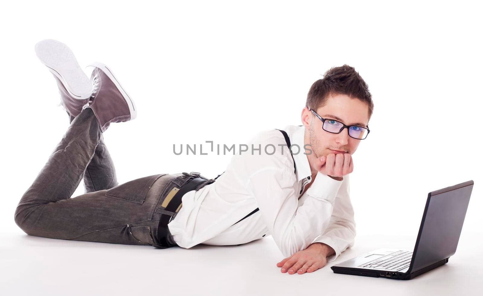 Businessman lying in front of laptop. Isolated against a white background.