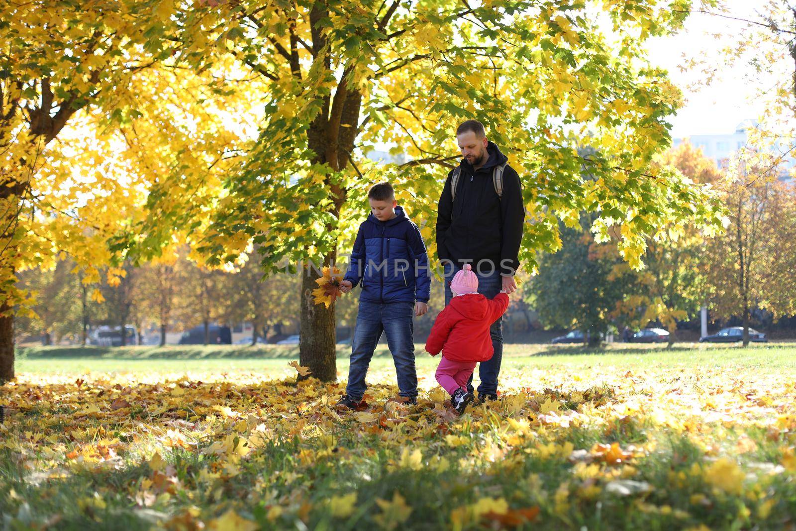 Happy father playing with his children outside in the park by paralisart