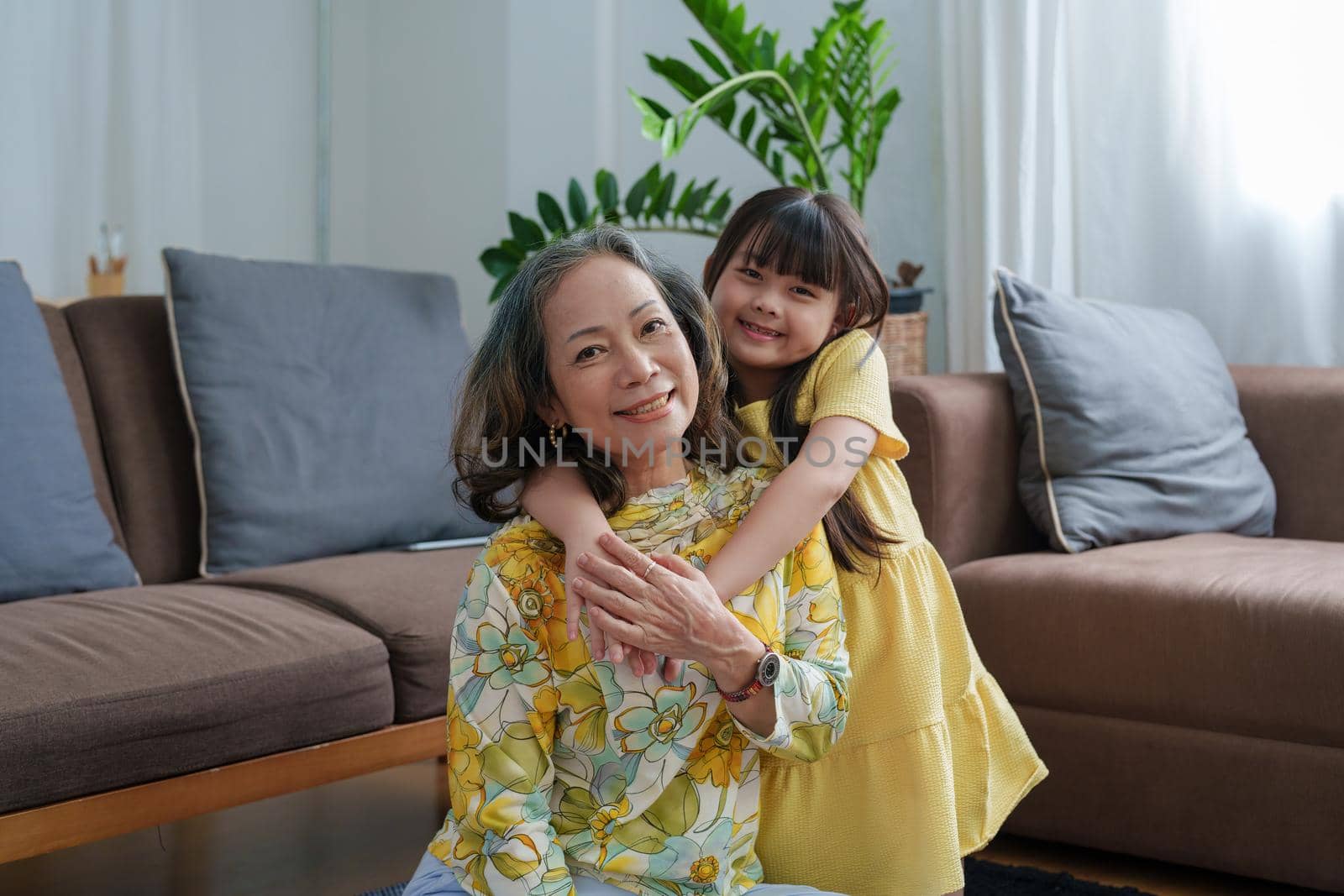 Asian portrait, grandma and granddaughter doing leisure activities and hugging to show their love and care for each other by Manastrong