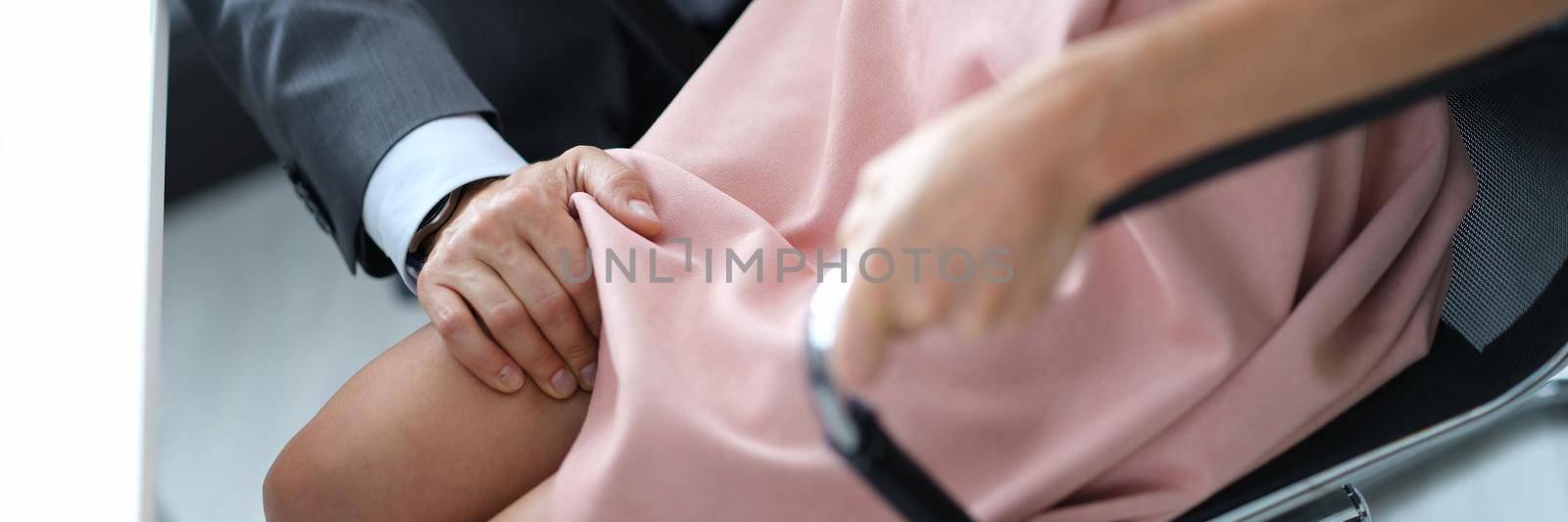 Male hand of leader on knee of employee closeup by kuprevich