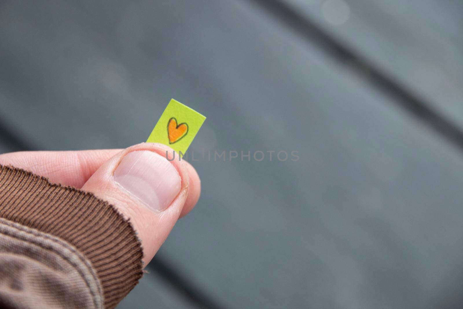 Hand holding a tag with a drawn heart. Love concept. High quality photo