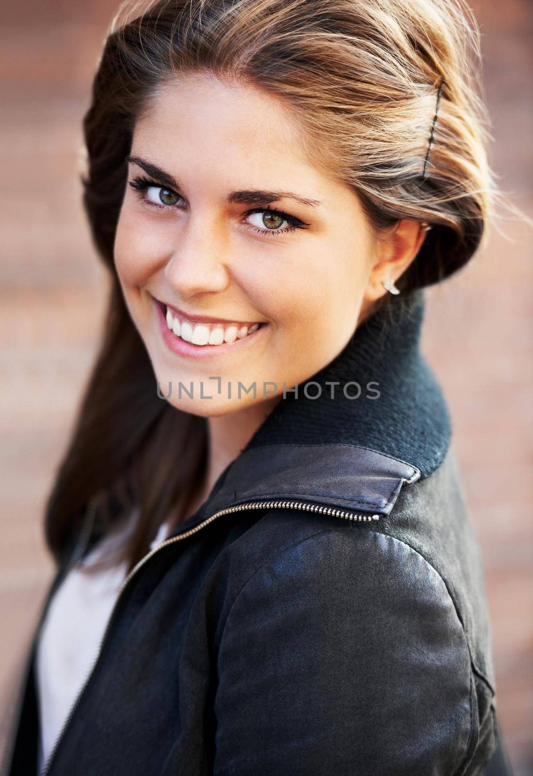 Flashing a candid smile. Portrait of an attractive young woman outdoors in the city. by YuriArcurs