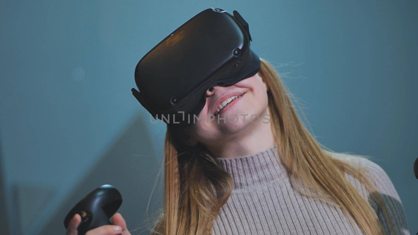 The girl plays virtual reality games in the club