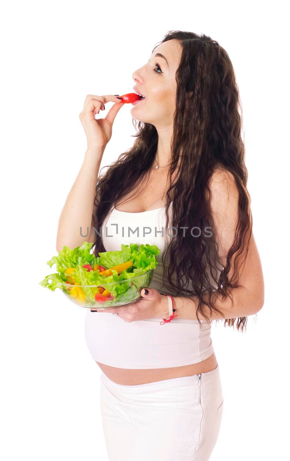Pregnant woman eating chopped salad, isolated on white.