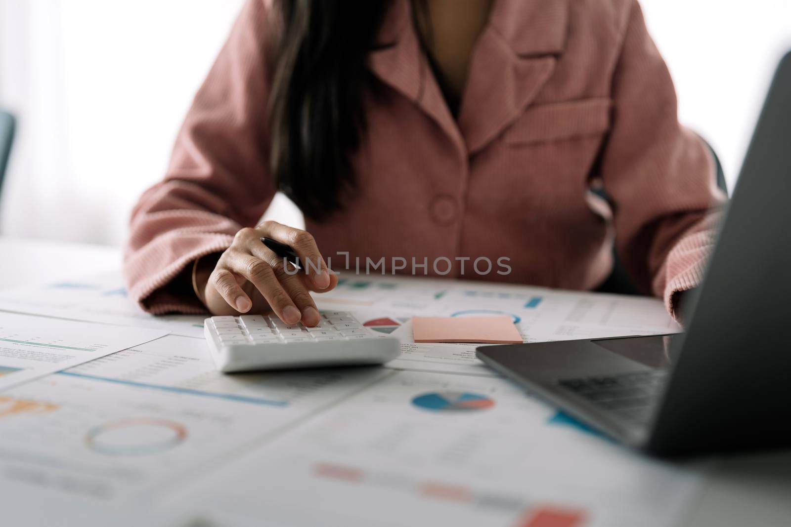 Business woman using calculator for do math finance on wooden desk in office and business working background, tax, accounting, statistics and analytic research concept.