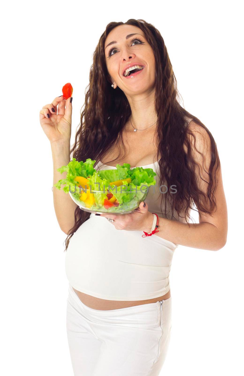 Pregnant woman eating chopped salad, laughing and looking up. isolated on white.